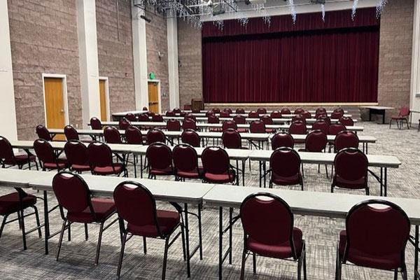 Event hall set up with long tables and chairs.